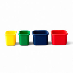 4 silicone snack pods that are meant to be used with planet box stainless steel lunchboxes primary colors yellow, green blue and red